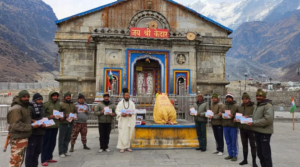 केदारनाथ में पूजित अक्षत और निमंत्रण पत्र के साथ पुजारी